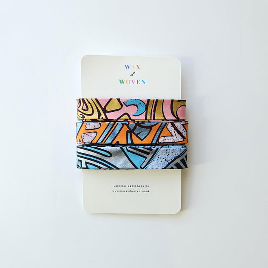 Set Of 3 African Wax Geometric Metallic Fabric Bias Binding. 5 Metres Each x  2.5cm Wide in Pink, Orange & Blue For Crafting And Quilting.